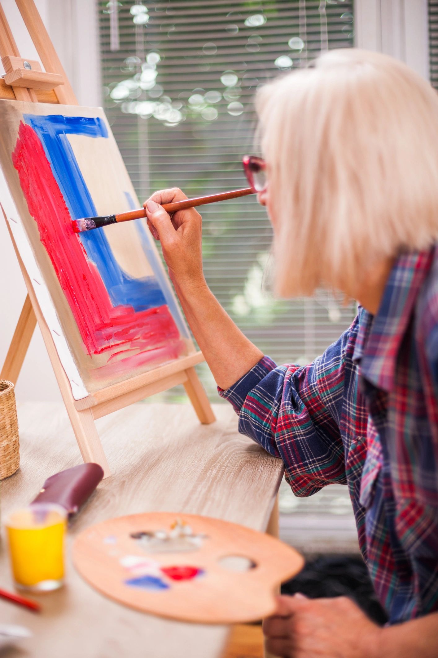Senior woman painting at home